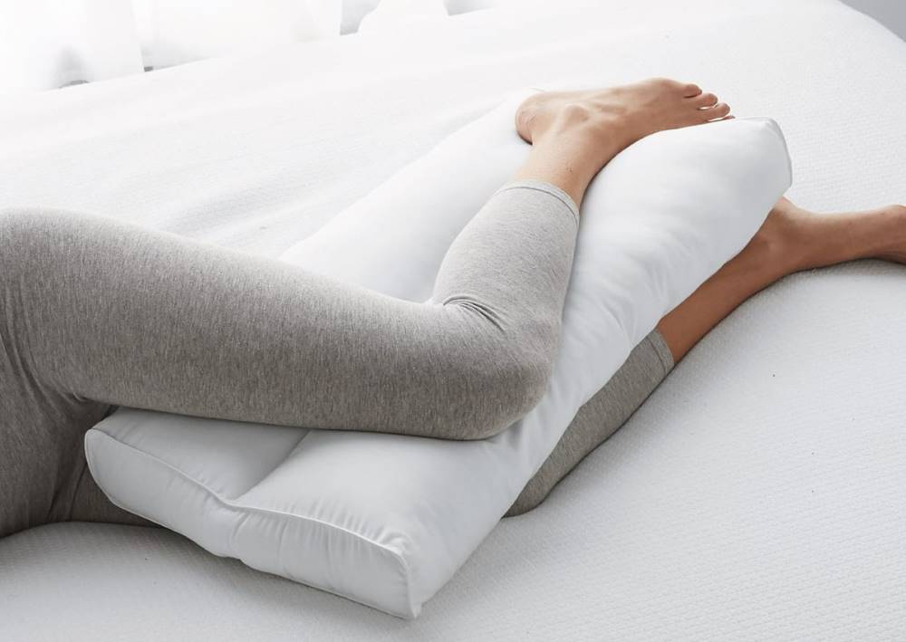 Los beneficios de dormir con una almohada entre las piernas